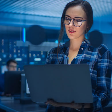 woman in tech office holding laptop