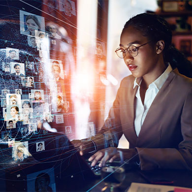 professional on laptop with holograph of faces and lines