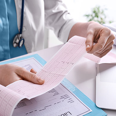 ekg tech reads test result on heart scan