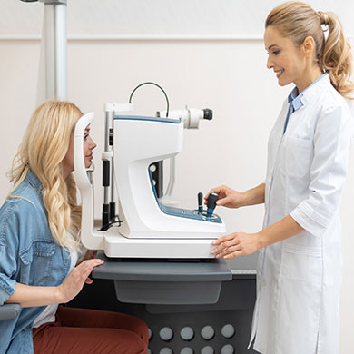 optometric technician performs vision test on patient